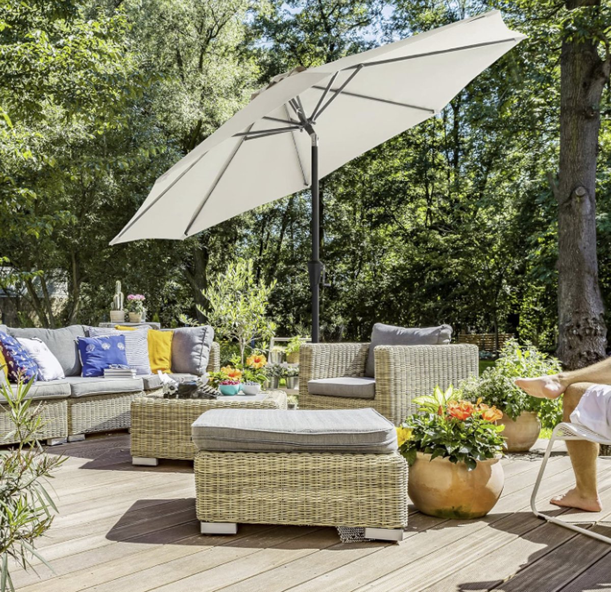 MAZAZU Parasol Mix in beige boven een loungeset op een houten terras
